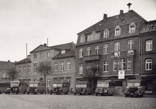 Bild vergrößern: Ratzeburg. Marktplatz mit Bussen der Ratzeburger Kraftverkehrsgesellschaft. Rathaus (links), britische Militärkommandantur (rechts).1946. Foto im Kreismuseum in Ratzeburg.